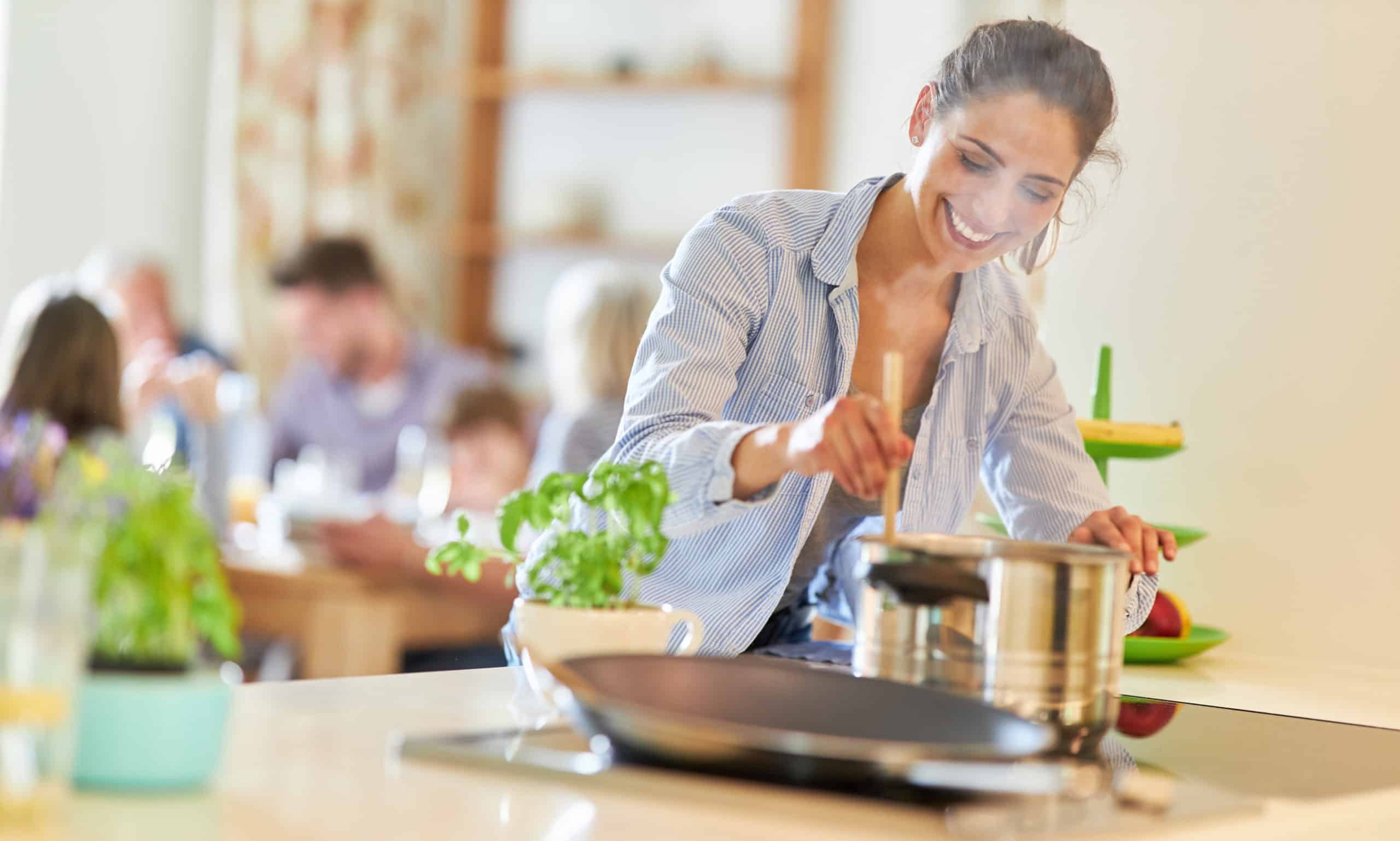 Frau beim kochen am Herd rührt im Kochtopf