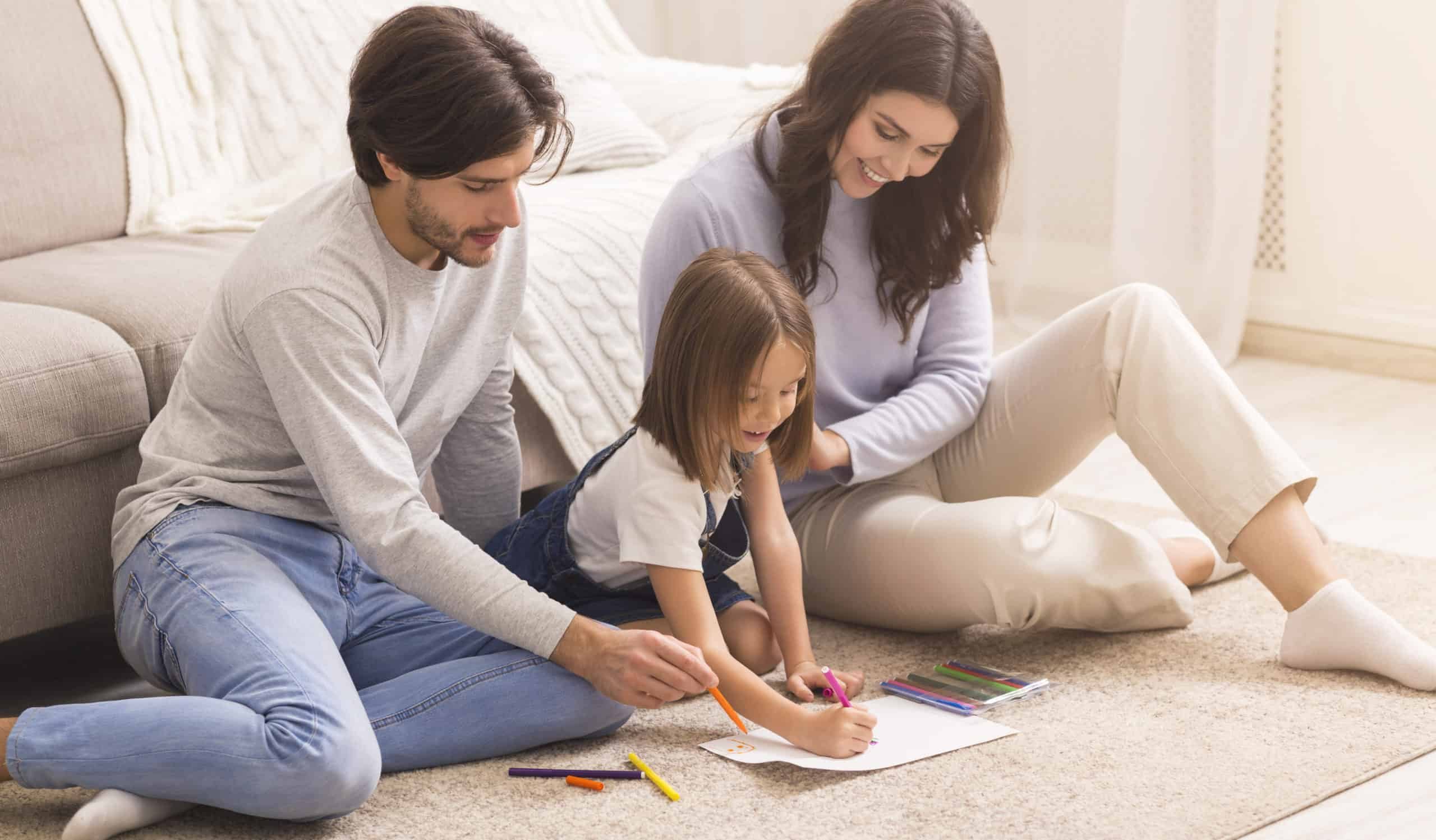 Millennial Parents Drawing With Their Little Daughter On Floor At Home
