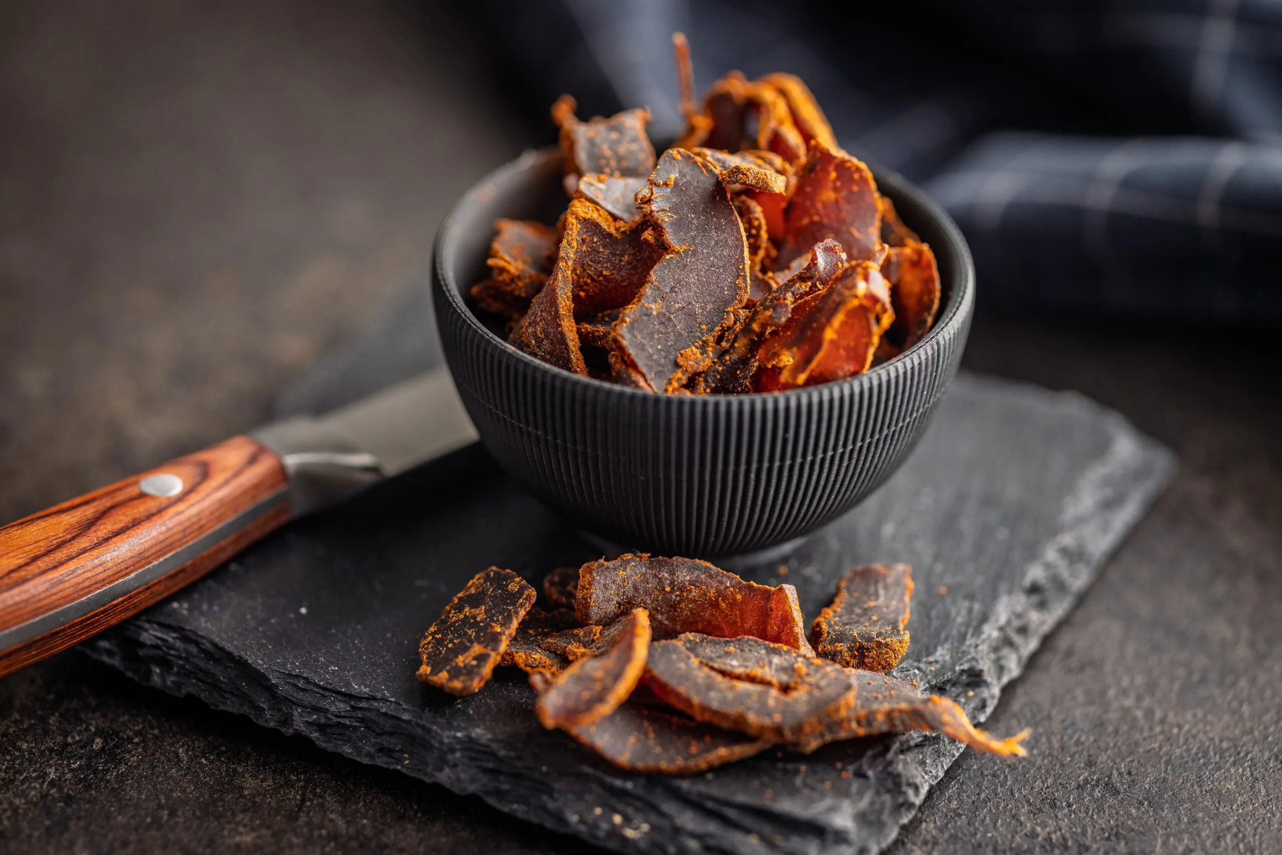 Beef,Jerky.,Dried,Spiced,Meat,On,A,Black,Table. Food, Food Presentation, Bowl