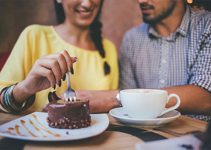 people eating cake and drinking coffee together