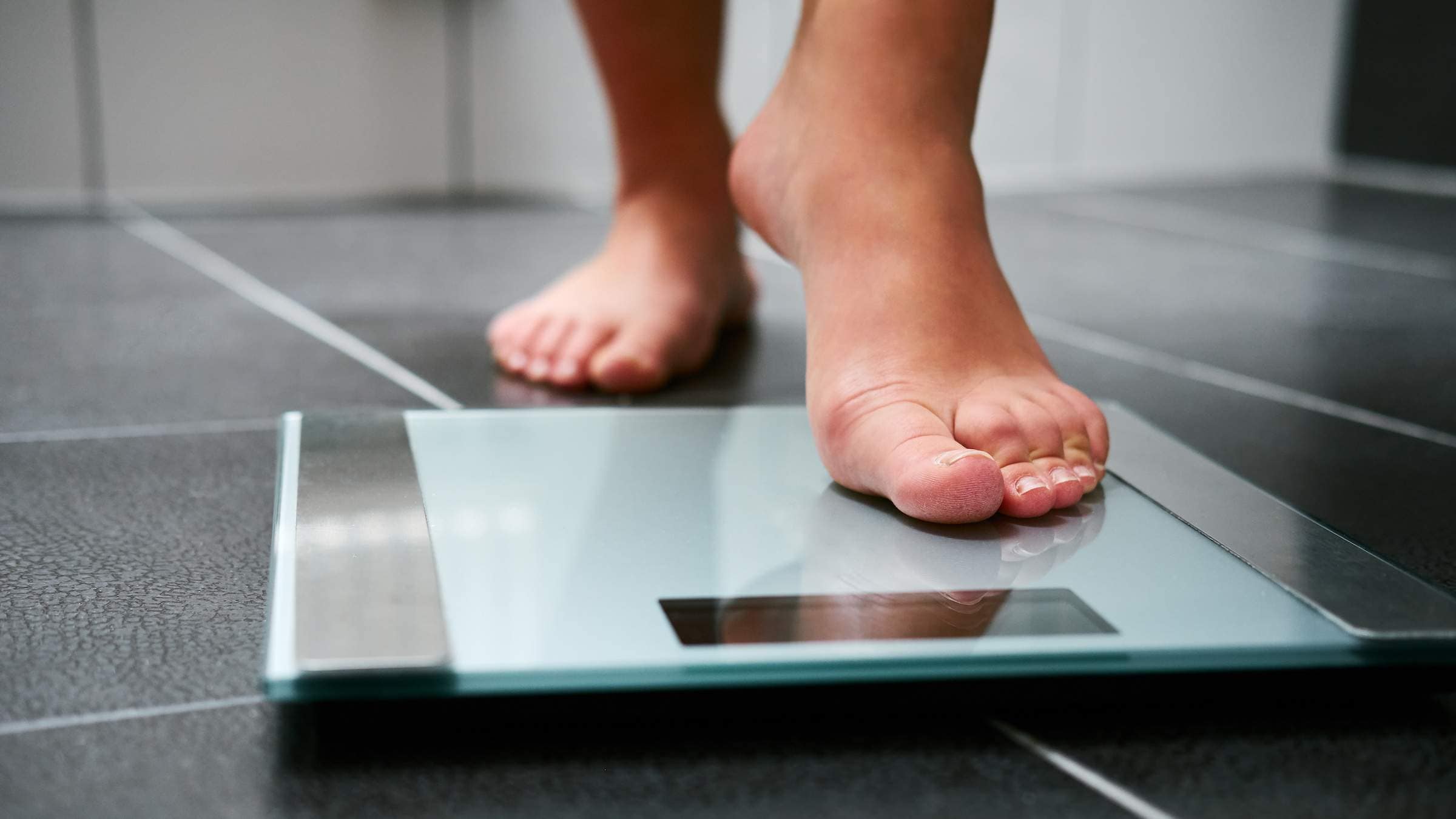 woman stepping on to a scale